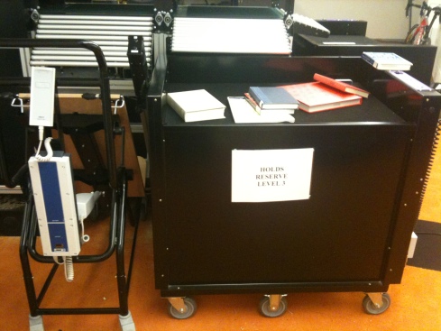 Automatically loading trolley next to a automatic raising returns bin on ARS at ERC Library, University of Mebourne